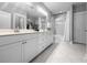 Bright bathroom with dual sinks, white cabinetry, and marble-look tile floor and shower at 3933 Bessemer Rd, Mount Pleasant, SC 29466