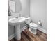 Charming half-bathroom with pedestal sink and rustic wood-look flooring at 3933 Bessemer Rd, Mount Pleasant, SC 29466