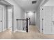 Upstairs hallway featuring carpet, wood railing, and doors leading to rooms at 3933 Bessemer Rd, Mount Pleasant, SC 29466