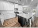 Bright kitchen boasts white cabinets, stainless appliances, island with seating, and wood-look flooring at 3933 Bessemer Rd, Mount Pleasant, SC 29466