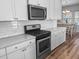 Close-up of a kitchen featuring stainless steel appliances, white cabinets, and tile backsplash at 3933 Bessemer Rd, Mount Pleasant, SC 29466