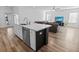 Kitchen island includes a sink and a dishwasher with seating, and a view to the living room at 3933 Bessemer Rd, Mount Pleasant, SC 29466
