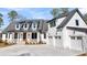 Beautiful two-story home boasts a three-car garage and charming front porch with ample parking on a concrete driveway at 3949 Bulow Landing Rd, Ravenel, SC 29470