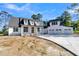 Striking front exterior with a three car garage and a freshly poured driveway at 3949 Bulow Landing Rd, Ravenel, SC 29470