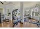 Bright home gym featuring hardwood floors, lots of natural light, and an array of exercise equipment at 3949 Bulow Landing Rd, Ravenel, SC 29470