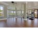 Bright gym area with treadmills, hardwood floors, and a wall of windows bringing the outside in at 3949 Bulow Landing Rd, Ravenel, SC 29470