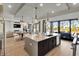 Modern kitchen boasts an island with a sink, pendant lights, and an open floorplan to the living room at 3949 Bulow Landing Rd, Ravenel, SC 29470