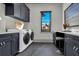 Laundry room with front-loading washer and dryer and dark cabinetry at 3949 Bulow Landing Rd, Ravenel, SC 29470