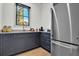 A neutral pantry is well-appointed with stainless steel refrigerator and custom cabinets at 3949 Bulow Landing Rd, Ravenel, SC 29470