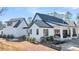 Exterior of the home with a covered patio, dark framed windows, and stylish landscaping at 3949 Bulow Landing Rd, Ravenel, SC 29470