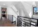 Bright foyer boasts modern black iron railing on staircase and hardwood floors at 3949 Bulow Landing Rd, Ravenel, SC 29470