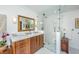 This bright bathroom offers a glass shower, marble countertops, and elegant wood cabinets at 3970 Betsy Kerrison Pkwy, Johns Island, SC 29455