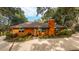 Exterior view of a well-maintained orange home with brick pathway, mature trees, and fresh landscaping at 3970 Betsy Kerrison Pkwy, Johns Island, SC 29455