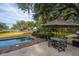 Outdoor pool and patio area including a pool, dining table under an umbrella, and lush green surroundings at 3970 Betsy Kerrison Pkwy, Johns Island, SC 29455