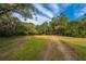 Driveway leading to a beautiful home surrounded by a large yard and mature trees at 3970 Betsy Kerrison Pkwy, Johns Island, SC 29455