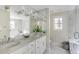 Bright bathroom with marble countertops, double vanity, large mirrors and access to the glass enclosed shower at 40 New St, Charleston, SC 29401