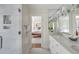 Bright bathroom featuring marble countertops, double vanity, and a view of the main bedroom through an open doorway at 40 New St, Charleston, SC 29401