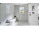 A spacious glass enclosed shower is adorned with marble walls, a built in shower bench, and a window for natural light at 40 New St, Charleston, SC 29401