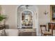 Dining room view framed by arched doorways, elegant chandelier and furniture at 40 New St, Charleston, SC 29401