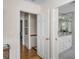 Hallway with open doorways leading to a bedroom and a bathroom with white cabinets at 40 New St, Charleston, SC 29401