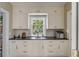 A stylish kitchenette with white cabinets, black countertop, and a window that provides natural light at 40 New St, Charleston, SC 29401