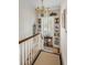Second floor staircase with a decorative display niche and a brass chandelier at 40 New St, Charleston, SC 29401