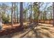 A spacious backyard with tall mature trees, a pine straw covering, and a wooden fence at 405 Simmons Ave, Summerville, SC 29483