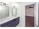 Bathroom boasts double vanity, modern mirrors and fixtures, with view to bedroom with ceiling fan at 405 Simmons Ave, Summerville, SC 29483