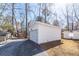 Detached white garage with a clean design, gravel driveway and landscaping surrounded by mature trees at 405 Simmons Ave, Summerville, SC 29483