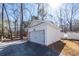 Detached white garage with a clean design, gravel driveway and landscaping surrounded by mature trees at 405 Simmons Ave, Summerville, SC 29483
