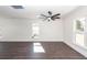 Large living room with white walls, hardwood floors, large windows and stylish ceiling fan at 405 Simmons Ave, Summerville, SC 29483