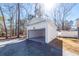 View of an open garage with an empty concrete floor, a gravel driveway, and landscaping at 405 Simmons Ave, Summerville, SC 29483