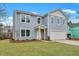 Two-story home with blue siding, an attached garage and a manicured green lawn at 4179 Rising Tide Dr, Summerville, SC 29485