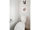 Bright, clean bathroom with a white toilet and simple framed leaf artwork at 519 Bank St, Mount Pleasant, SC 29464