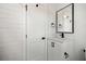 A bright bathroom featuring white subway tile walls, a vanity with black hardware, and a door at 519 Bank St, Mount Pleasant, SC 29464
