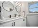 Bright bathroom features double vanity with round mirrors, matte black fixtures, and plenty of counter space at 519 Bank St, Mount Pleasant, SC 29464