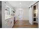 Charming kitchen with beverage cooler, white cabinets, and adjacent powder room with sliding barn door at 519 Bank St, Mount Pleasant, SC 29464