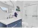 A well-lit bathroom with a navy vanity, a large mirror, and modern shower at 544 Beverly Dr, Summerville, SC 29485