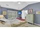 A well-lit bedroom with blue walls, a large window, and a sliding barn door at 544 Beverly Dr, Summerville, SC 29485