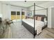 Bedroom with a modern four-poster bed, hardwood floors and backyard views at 640 Cottage Landing Drive, Summerville, SC 29485