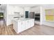 Well-lit kitchen with modern white cabinets, a sleek center island, and stainless steel appliances over attractive hardwood floors at 640 Cottage Landing Drive, Summerville, SC 29485