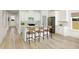 Open-concept kitchen with a central island, stainless steel appliances, and breakfast bar with seating flowing to an entry hallway at 640 Cottage Landing Drive, Summerville, SC 29485