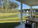 Covered patio with outdoor dining area overlooking a pond and landscaping at 640 Cottage Landing Drive, Summerville, SC 29485