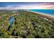 Breathtaking aerial view of a coastal community with lush greenery, a sandy beach, and stunning ocean views at 65 Surfsong Rd, Kiawah Island, SC 29455