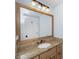 Bathroom featuring a light wood vanity with granite countertop, decorative mirror, and blue walls at 65 Surfsong Rd, Kiawah Island, SC 29455