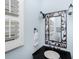 Stylish powder room featuring a decorative mirror, dark countertop and shuttered window at 65 Surfsong Rd, Kiawah Island, SC 29455