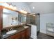 Bathroom with double granite vanity, glass-enclosed shower, and a large mirror at 65 Surfsong Rd, Kiawah Island, SC 29455