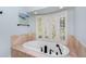 This bathroom features a soaking tub surrounded by stone and a large window at 65 Surfsong Rd, Kiawah Island, SC 29455
