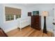 Cozy bedroom with a crib, dresser, wood floors, and a window with a woven shade at 65 Surfsong Rd, Kiawah Island, SC 29455