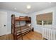 Bedroom with a bunk bed, crib, and window with a woven shade at 65 Surfsong Rd, Kiawah Island, SC 29455
